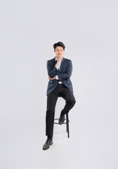 Full body image of young Asian business man sitting in chair on white background