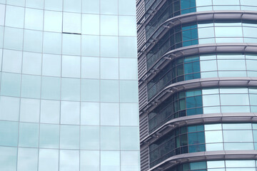 Obraz premium A modern office building facade with large glass windows that reflect its surroundings