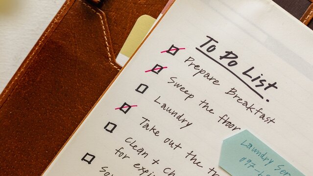 Open planner with a to-do list on a desk. Organized workspace with planner and notes. Efficient planning with a to-do list. Top view of planner with to-do list on the desk. Homework to do list