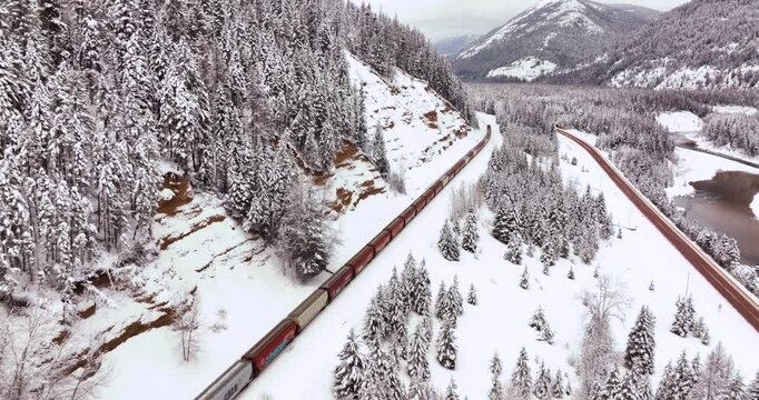 Snow-Covered Forest and Freight Train Aerial Drone Glacier National Park