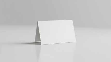 Blank white tent card mockup on reflective surface, studio shot, minimalist background, for design presentation