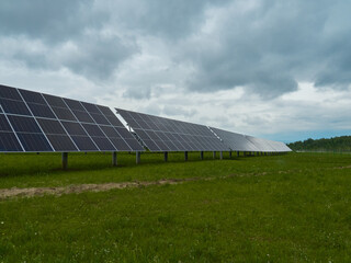Solar panels in a field under a cloudy sky. Clean energy and renewable resources.