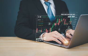 A businessman in a suit analyzes market data on a laptop, showcasing financial graphs and trading indicators.