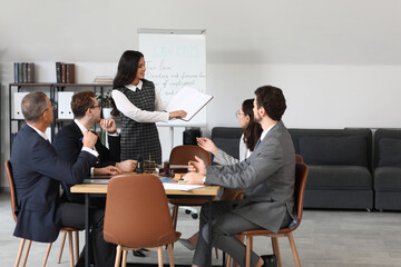 Female lawyer working with colleagues at table in office