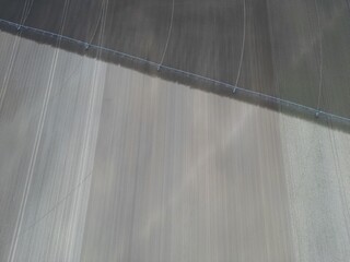 Agricultural watering boom on a field irrigated on one side and dry on the other - Rampe d'arrosage...