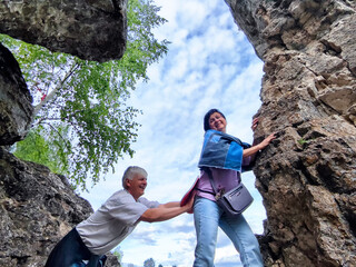 Friends enjoying an adventurous moment while climbing rocky terrain in a beautiful outdoor setting