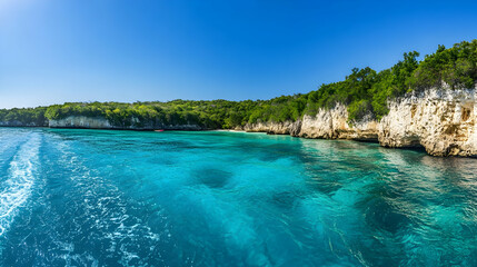 A wide-angle view of a pristine coastline seen from a boat, featuring aquamarine waters, dramatic...