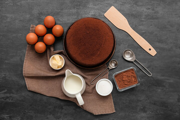 Composition with sponge cake layers and fresh ingredients on dark background