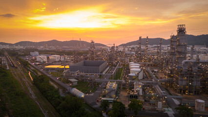Fototapeta premium Oil Refinery plant at sunset. Gas Chemical Equipment Prodiction import export Concept, Crude Oil Refinery Plant Steel Pump Pipe line and Chimney and Cooling tower, Chemical Petrochemical