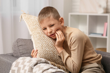 Little boy suffering from toothache at home