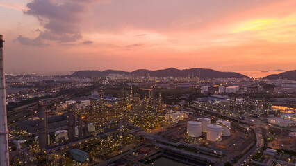 Fototapeta premium Oil Refinery plant at sunset. Gas Chemical Equipment Prodiction import export Concept, Crude Oil Refinery Plant Steel Pump Pipe line and Chimney and Cooling tower, Chemical Petrochemical