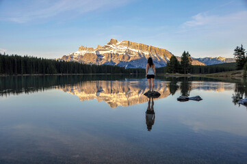 Fototapeta premium Stood on a rock at Two Jack Lake in Banff National Park watching the sunrise illuminate Rundle Mountain 