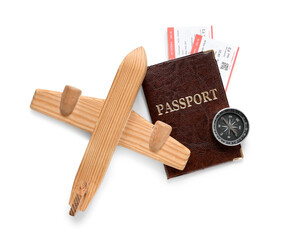 Passport with tickets, wooden plane and compass on white background