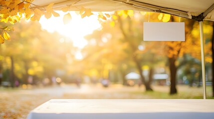 A minimalist sales tent with a simple table covered in a crisp white cloth, blank rectangular storefront sign positioned above the entrance, soft blurred background of a park setting, warm golden