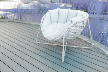 Outdoor space with a white cushioned chair for relaxation