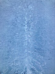 縦方向に撮影した氷の壁のクローズアップ。たくさんの細かいヒビ。反対側から光が差し込んでいる。素材。