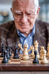 A grandfather playing chess with a smiling board, the pieces waving like friends