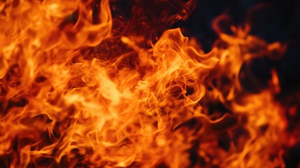 Obraz premium Close up of vibrant flames dancing against a dark background creating a dramatic and intense visual texture for various designs