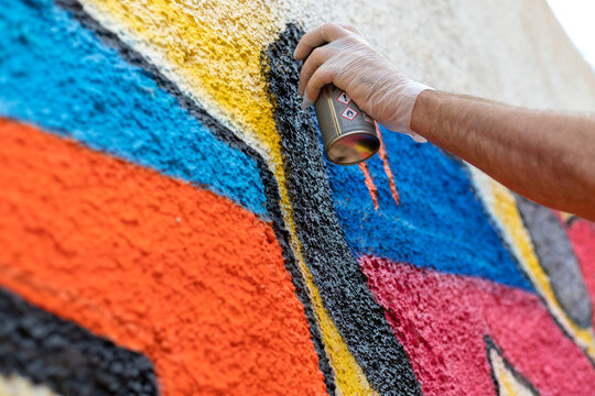Close-Up of a Hand Painting Graffiti on a Wall