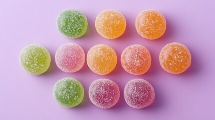 Obraz premium Vibrant assorted gummy candies arranged on a smooth purple backdrop for enticing confectionery visuals