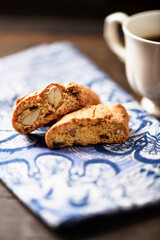 Cantuccini (Italian cookies) and a cup of coffee on dark wooden background. Close up.