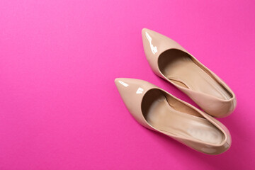 Stylish classic women's beige high heel shoes on color background. Top view, flat lay