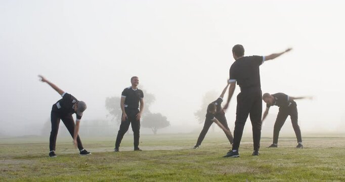 Cricket team warming up with stretching exercises on foggy field in morning - Powered by Adobe
