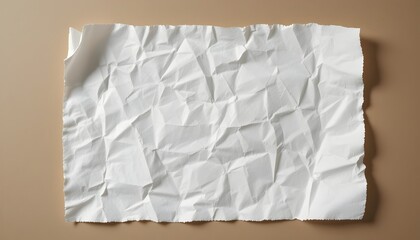 Obraz premium A worn and crumpled sheet of white paper lies flat against a neutral-coloured background