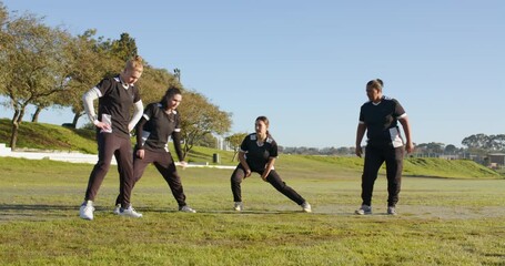 Stretching on field, female cricket team warming up before practice session - Powered by Adobe
