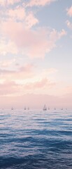 Obraz premium A beautiful sunset over the ocean shows a range of pastel shades, with sailboats drifting in the distance, turquoise, silhouette, serene, ocean