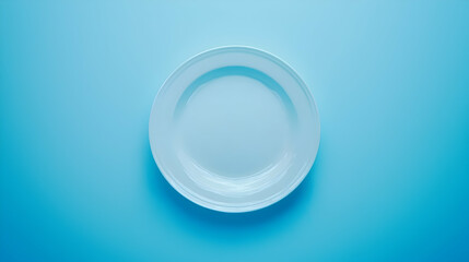 Empty white plate on blue background, overhead view, minimalist food photography, perfect for menu design.