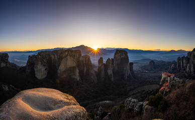 Sunset over Meteora. Amazing wide angle photo with the landscape of Meteora, iconic place with Greek orthodox monasteries in the mountains, during sunset. Travel to Greece.