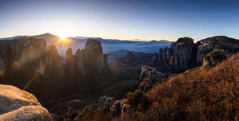 Sunset over Meteora. Amazing wide angle photo with the landscape of Meteora, iconic place with Greek orthodox monasteries in the mountains, during sunset. Travel to Greece.