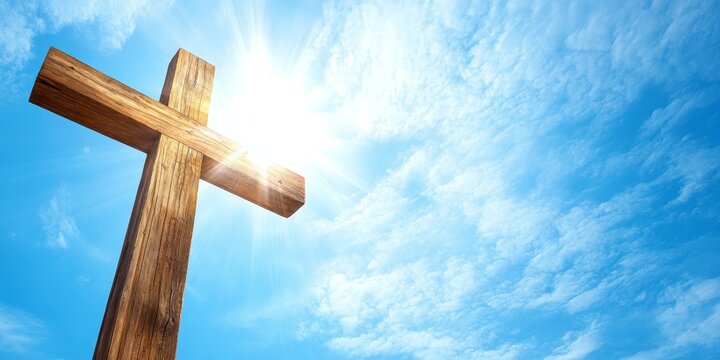 A wooden cross set against a bright blue sky illuminated by gentle sunlight serves as a powerful symbol for reflection and meditation, emphasizing themes of Christianity.