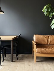 Minimalist living space featuring a brown leather sofa, wooden table, black chair, and green plant against a dark wall.