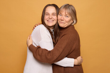 Two women share a warm embrace, smiling widely while enjoying a moment of happiness together. The...