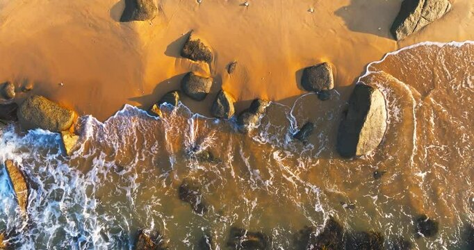 Aerial view top view of sandy beach in the golden morning sun light