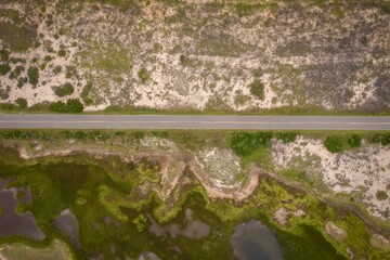 Aerial view of road between dry land and wetlands