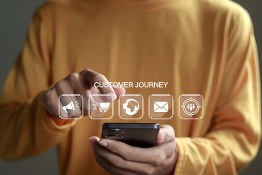 Customer journey concept. Person using smartphone with customer journey icon on virtual screen. Journey evaluation, Boost satisfaction, encourage repeat business and drive revenue growth.