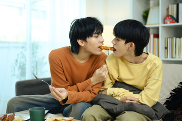 Romantic gay couple enjoys a casual meal together in living room