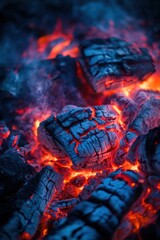 Fototapeta premium Close-up view of vibrant fire flames texture showcasing intricate details in bright orange and deep blue on glowing charred wood