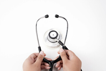 hand holding stethoscope on white desk