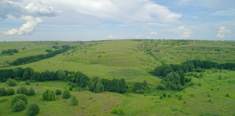 Obraz premium Large, open field with a few trees scattered throughout
