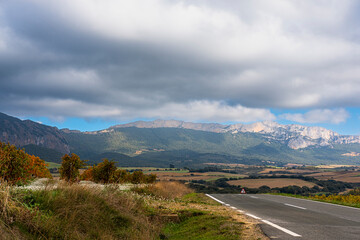 A captivating view showcasing a winding road leading into majestic mountains under an overcast sky, perfect for nature lovers and adventure seekers alike in a serene setting in Navarra Spain