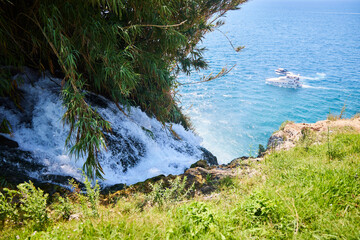 The waters of a stormy mountain river merge down to become a waterfall. Antalya, Turkey