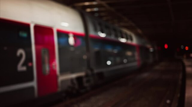 Blurred view of people and trains moving through the Cannes train station in the evening