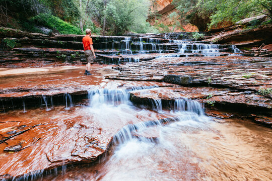 Man standing in the river, Arch Angel Falls, Zion National Park, Utah, United States