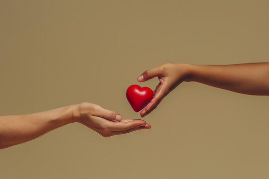 Main tendant un c&oelig;ur rouge &agrave; une autre main, Saint valentin amour mais aussi don d'organe. Donner son c&oelig;ur 