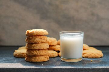 Milk in glass and cookies on the table, closeup of photo