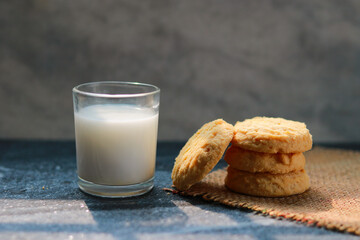 Milk in glass and cookies on the table, closeup of photo